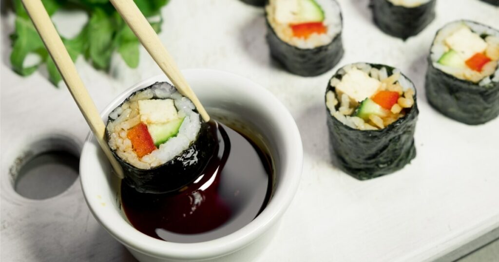 dipping vegan sushi in soy sauce